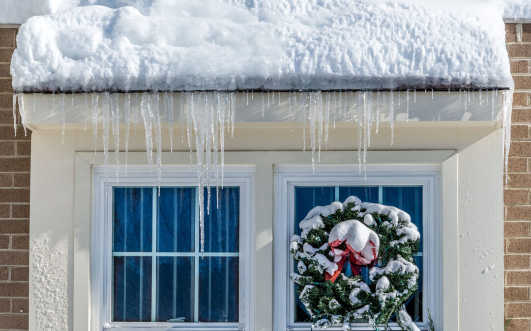 Wreath on window under snowy roof. winter roof maintenance tips.