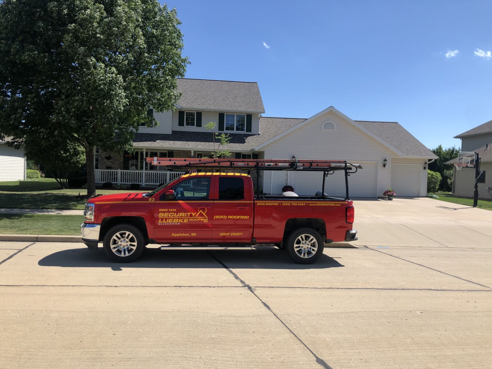Roofing truck in front of a house.