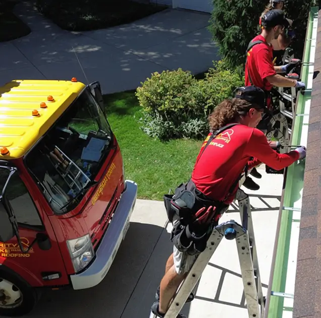 slr-crew-at-work SLR crew in their bright red uniform shirts, installing gutters on a home