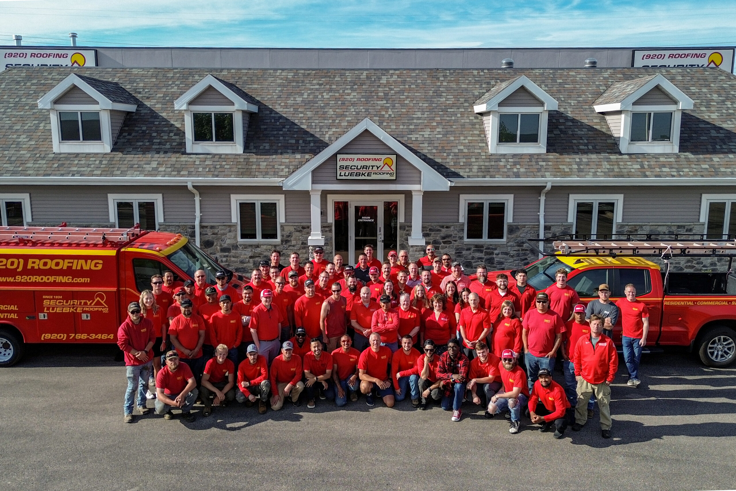 DCIM100MEDIADJI_0967.JPG Group photo of entire SLR team, in their bright red uniform shirts, posing proudly in front of their office